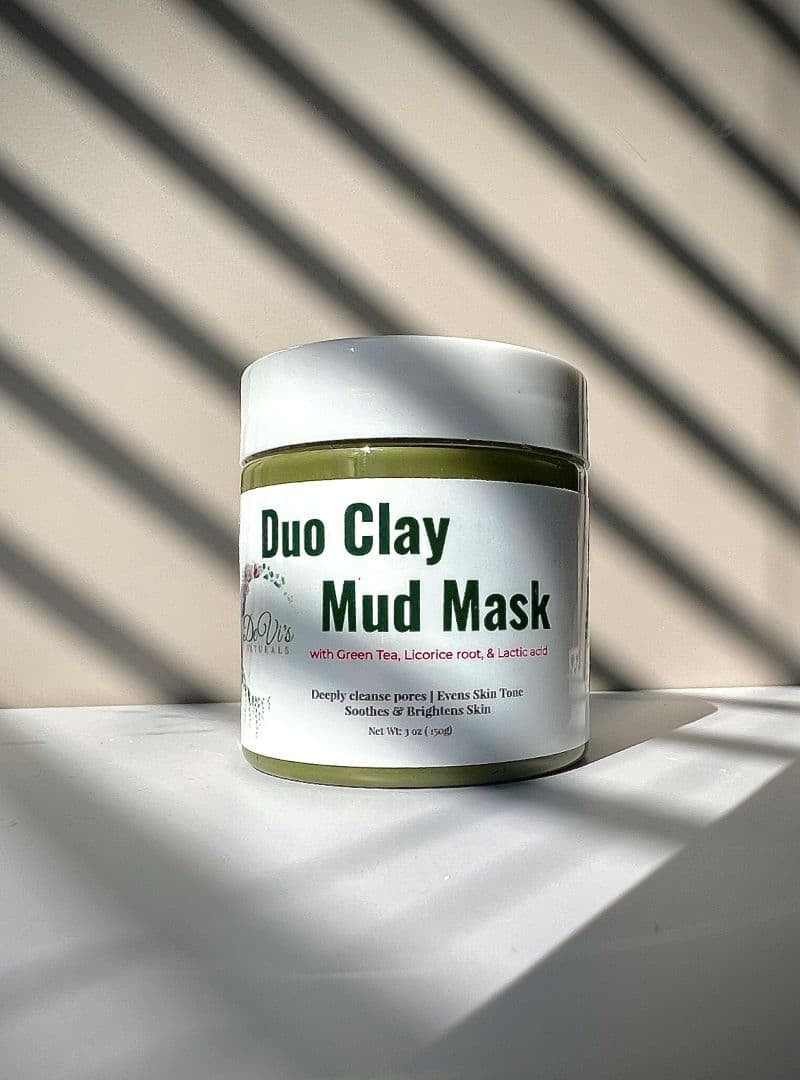 Duo Clay Mud Mask jar on a light surface with striped background