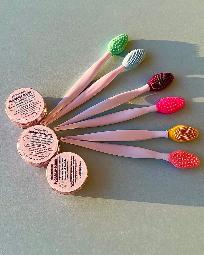 Set of lip scrubs with colorful heads and round containers on a light gray background