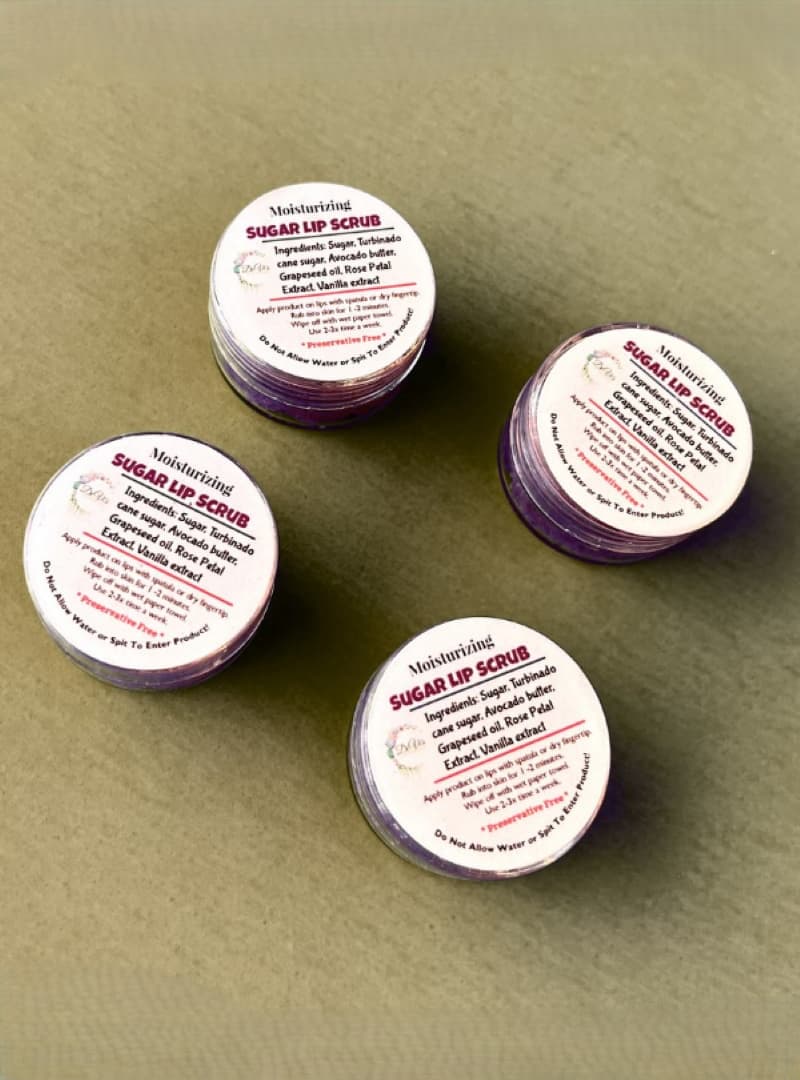 Four containers of sugar lip scrub on a beige background