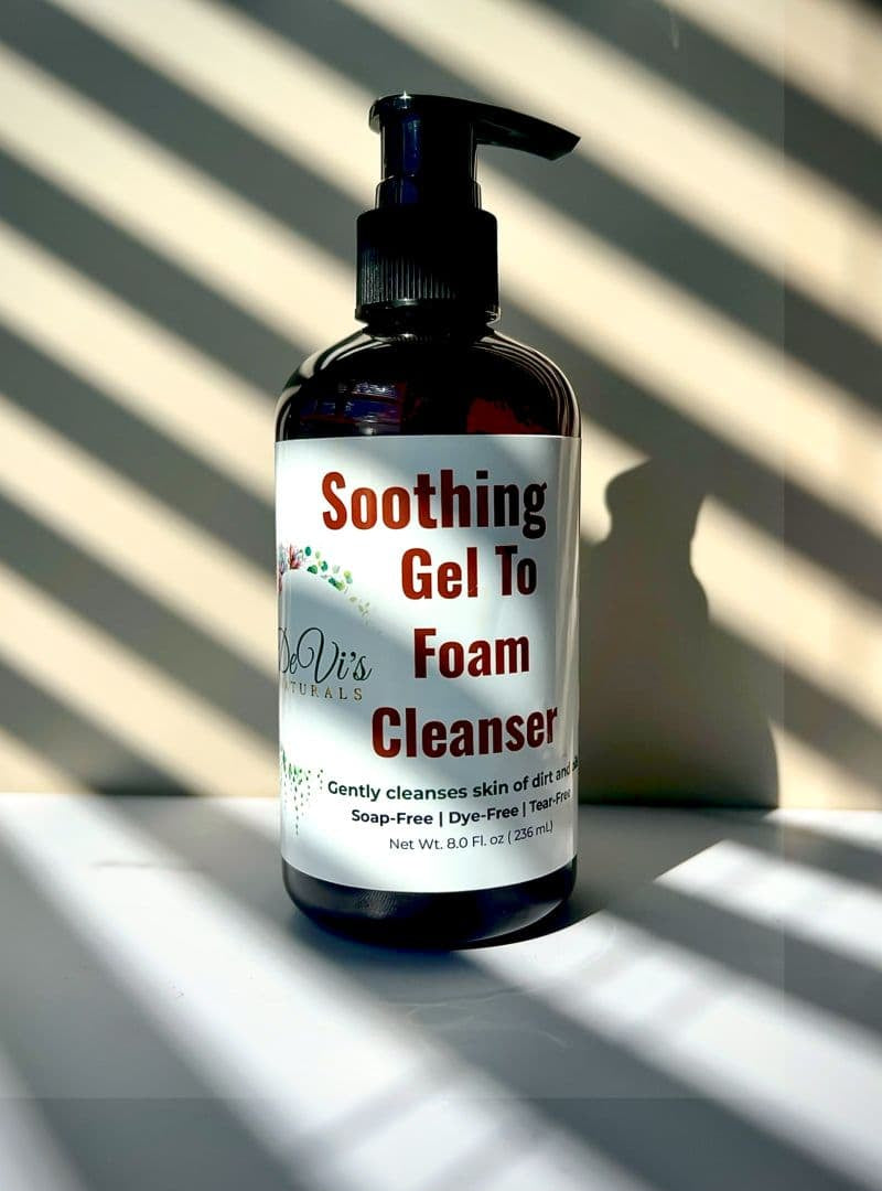 Bottle of 'Soothing Gel To Foam Cleanser' with a label on a surface with shadows.