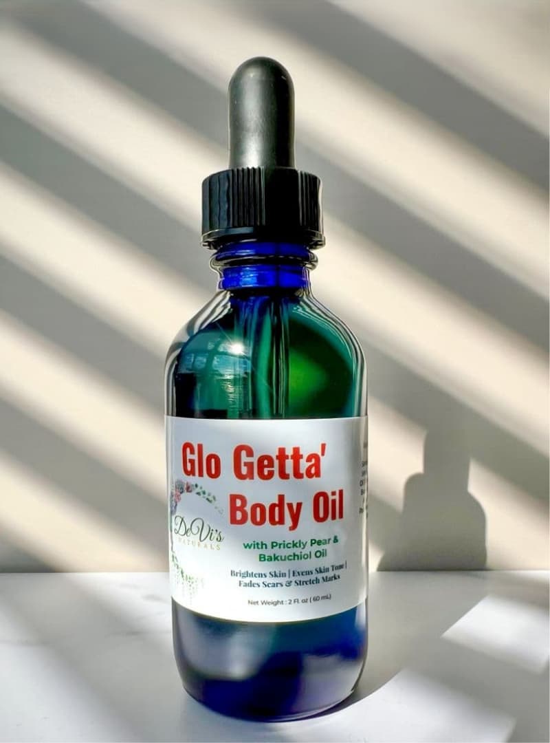Glo Getta' Body Oil bottle with dropper on a light background